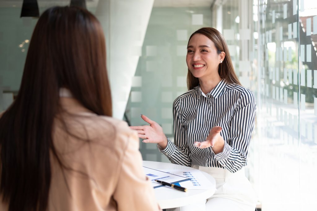 two businesswoman meeting in-person in a professional environment